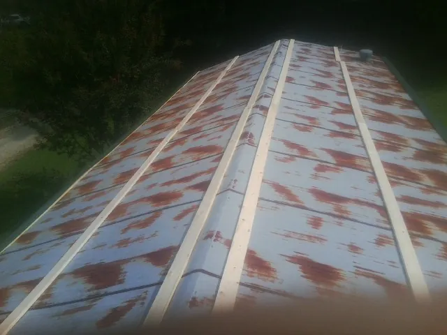 Rusted metal roof panels with new wood purlins before replacement — Storm Damage Roof Repair in Jewett by Roofing Brothers