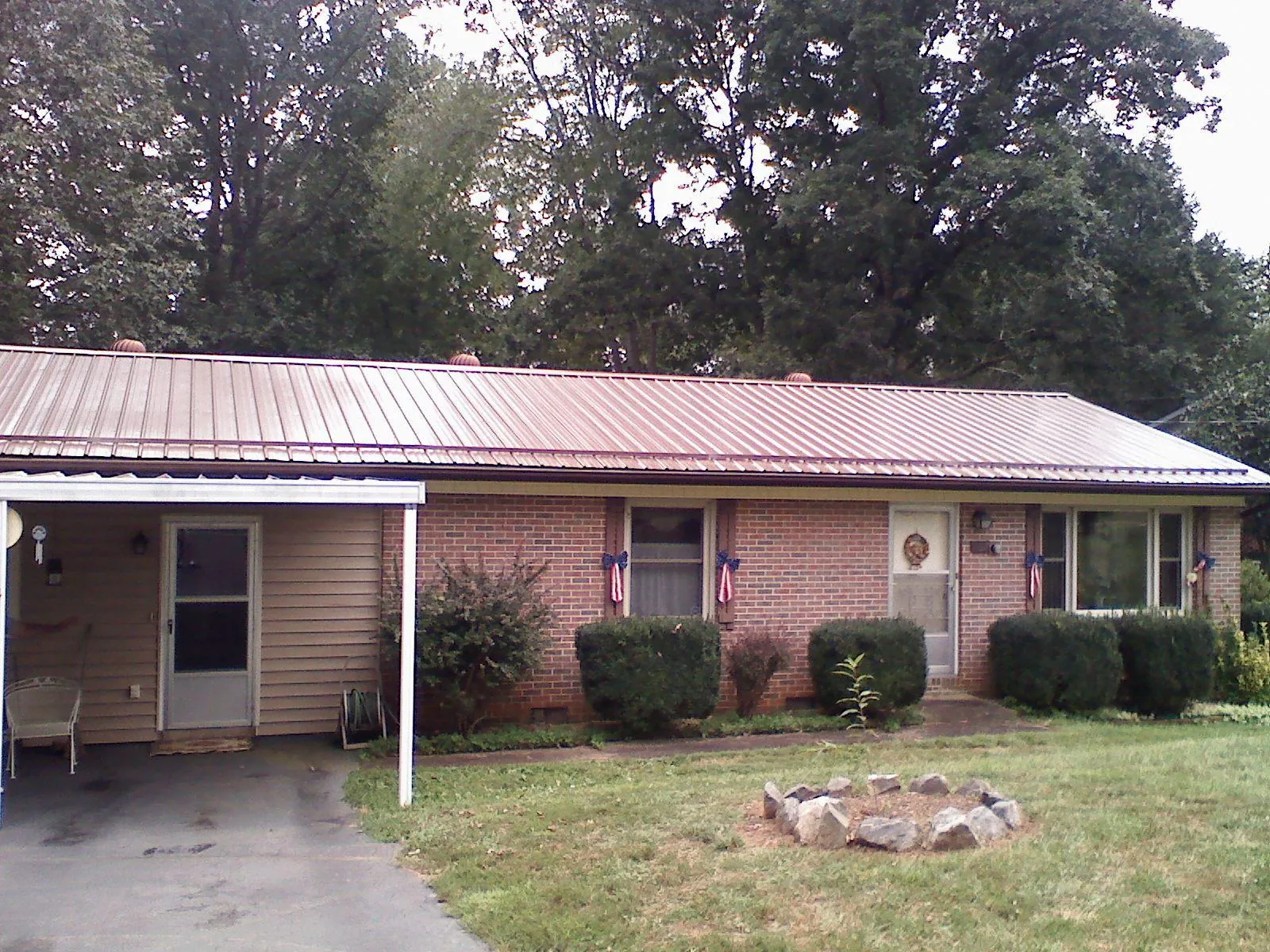 Bronze metal roof and carport on a brick ranch home — Roof Repair work by our crew in Jewett